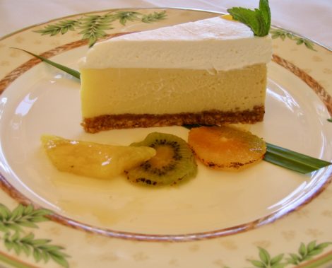 Cashew crusted piece of key lime pie with fruit garnish.