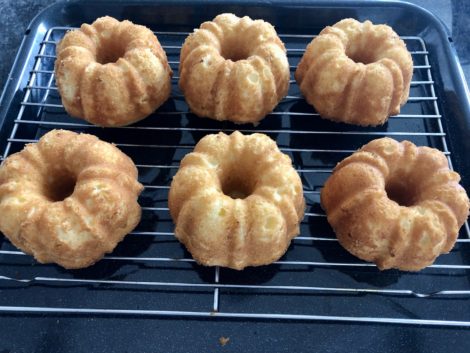 Lemon bundt cakes on a rack cooling.