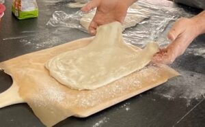 Stretching pizza dough.