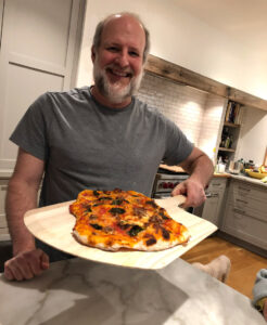 Mark Katzman holding pizza.