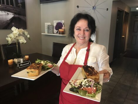 Katerina Sheshi holding Spanakopita at Cafe Nova