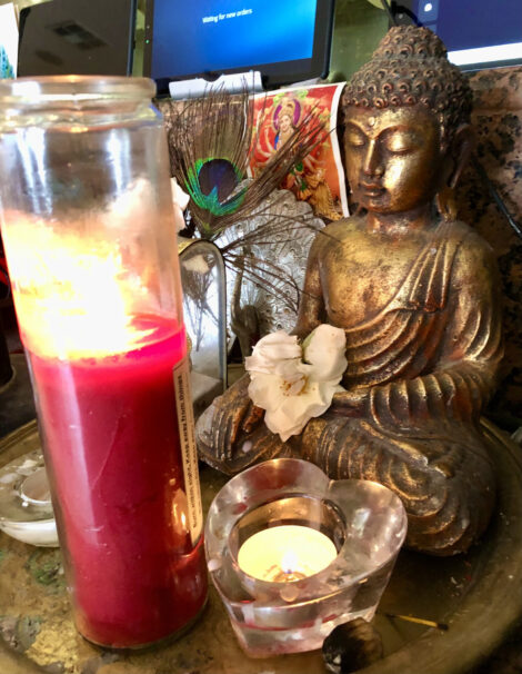 Shrine in Mayura with Buddah, candles and peacock feather.