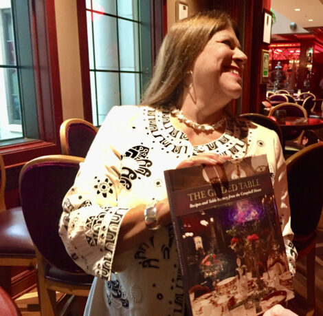 Suzanne holding a copy of The Gilded Table