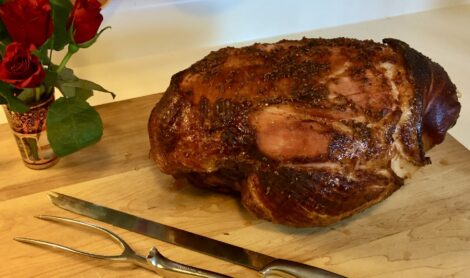 A Sugar Baked Holiday Ham on a cutting board.