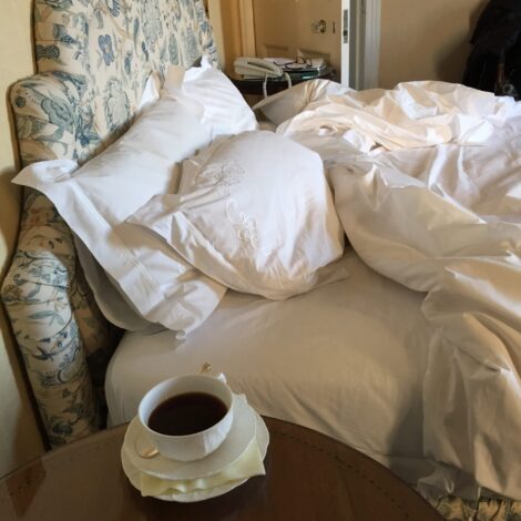 A plush bed at Inverlochy Castle Hotel  with coffee on a side table.