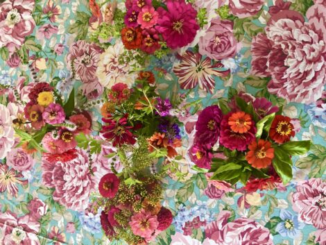 Bouquets of Zinnias on top of a flowered table cloth.