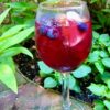 A glass of red-wine sangria garnished with blueberries