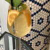 A glass of white wine sangria garnished with orange  wedges