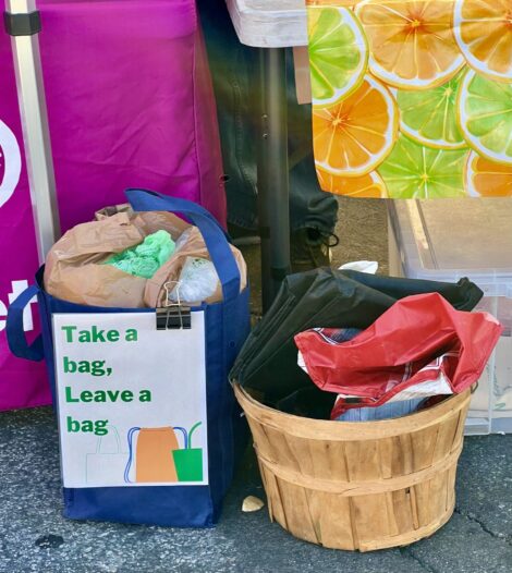 A basket inside the market telling people to take or leave a shopping bag.