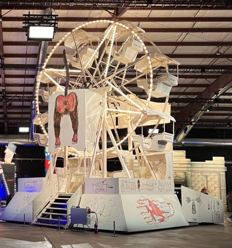 The back of a Ferris wheel envisioned by Jean-Michel Basquiat that show the painted bottom of an ape.