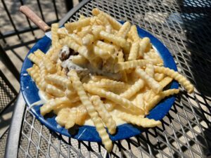 An openface horseshoe sandwich piled high with French fries.