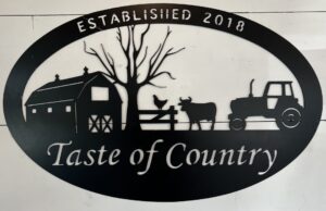A black and white sign reading Taste of Country